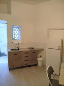 una cocina con fregadero y refrigerador en Casa di nonno leo, en Isquia