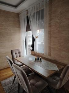 Un comedor con mesa y sillas y una ventana. en Apartman Havjar Zlatibor, en Zlatibor