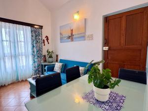 a living room with a glass table and a blue couch at La- Maria's By The Beach Goa in Benaulim