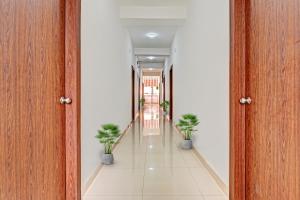an empty hallway with potted plants in a building at Hotel O Aura Hotel Rajdhani Residency in Rānchī