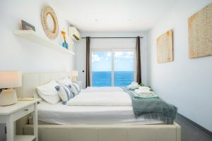a bedroom with a bed with a view of the ocean at Villa Azul in Cala Pi +26 photos