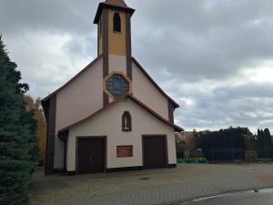 a large white church with a tall steeple at Zamek u Moniki Ryn in Ryn +2 photos
