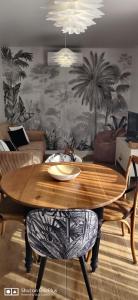 a living room with a wooden table and a couch at Maison 2 couchages in Aigrefeuille-dʼAunis