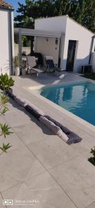 a swimming pool with a rolled up towel next to it at Maison 2 couchages in Aigrefeuille-dʼAunis