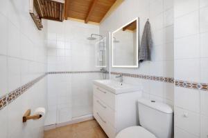 een witte badkamer met een toilet en een wastafel bij Finca Firmamento, Casa Sol in San Isidro +18 foto's