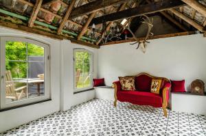 a living room with a red couch and two windows at Huus ant Dörpsdiek in Krummhörn