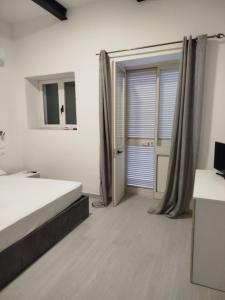 Un dormitorio con una cama y una puerta corrediza de vidrio. en Casa di nonno leo, en Isquia