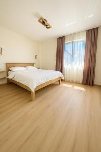 a bedroom with a large bed and a large window at Transrarau Lodge in Pojorîta
