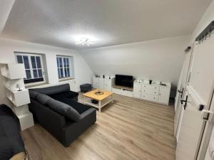 a living room with a couch and a table at Louis Hafenblick in Eckernförde +6 photos