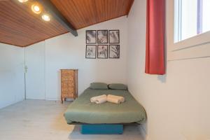 a bedroom with a green bed in a room at Maison Caupos in Biscarrosse