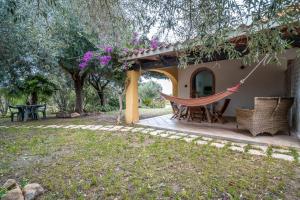 a hammock on the porch of a house at Casa Su Barone 1 in Orosei