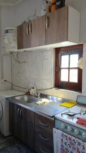 een keuken met een wastafel, een fornuis en een raam bij La Rosadita in Paraná