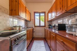 a kitchen with wooden cabinets and a stove at Casa Nicole in Sarroch