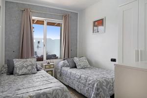 een slaapkamer met twee bedden en een raam bij Villa Fae in Playa Blanca +23 foto's