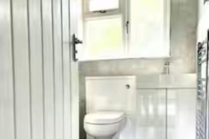 ein Badezimmer mit einer weißen Toilette und einem Schrank in der Unterkunft 2 Bed - Sleeps 6 - Parking - Town Centre in Reigate