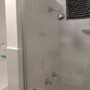 een badkamer met een douche met een glazen deur bij Dunes Alcove Mossel Bay Comfortable self catering accommodation just 900 meters from the beach and close to restaurants shops and local attractions in Vosburg