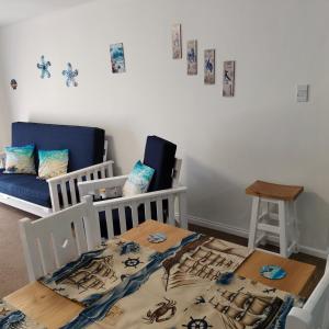 een kamer met een kinderbedje, een tafel en een bank bij Dunes Alcove Mossel Bay Comfortable self catering accommodation just 900 meters from the beach and close to restaurants shops and local attractions in Vosburg