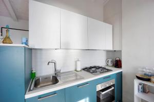 a kitchen with blue cabinets and a sink at Old city apartment seaview in Bordighera +13 photos