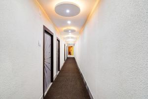 a hallway with white walls and a long hallway with white ceilings at Hotel O The Crown in Kolkata
