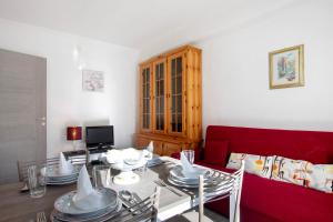 ein Wohnzimmer mit einem Tisch und einer roten Couch in der Unterkunft Casa Tua - Arvier in Arvier