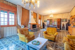 a living room with two chairs and a fireplace at Villa Joseph in Scicli +17 photos