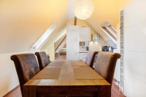 a dining room with a wooden table and chairs at Dachgeschosswohnung Wohllebe in Hannover