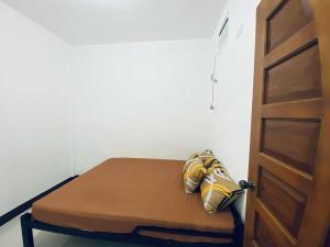 - un petit lit dans une chambre à côté d'une porte dans l'établissement Cozy Home in Malaybalay 2 Bedrooms and 1 Bathroom, à Malaybalay
