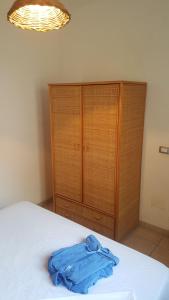 ein Schlafzimmer mit einem Bett und einem Holzschrank in der Unterkunft Bilocale 50 mt. dalla spiaggia 27 in Torre dell'Orso