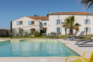 a house with a swimming pool in front of a house at La Belle Parenthèse à la Rochelle in Vergné