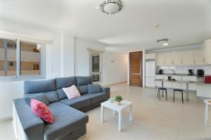 a living room with a blue couch and a kitchen at Tu Alojamiento En Playa Paraiso in Adeje
