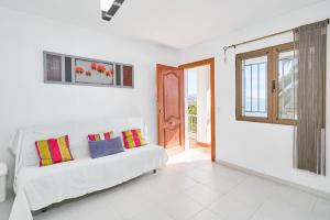 a living room with a white couch and a window at El Nido in Almuñécar +25 photos