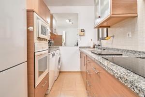 a kitchen with white appliances and wooden cabinets at El Nido in Almuñécar