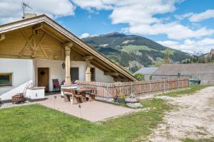 a house with a wooden deck with a picnic table at Stofnerhof Waldduft in Sarntal