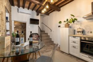 een keuken met een glazen tafel en een paar flessen wijn bij Casa Vesta in San Gimignano +14 foto's