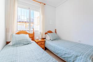 Dos camas en una habitación con ventana. en Horizon oasis_ sea house e chillout, en Santa Pola 36 fotos más