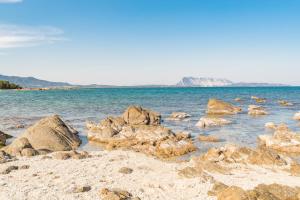 een strand met rotsen in het water bij Appartamento I Lecci in San Teodoro
