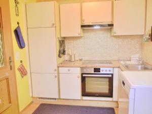 a small kitchen with white cabinets and a sink at Geräumiges Apartment mit Panoramabergblick in Sankt Michael im Lungau
