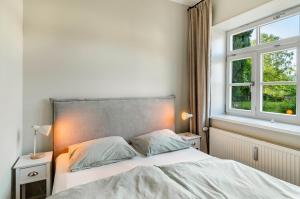 a bedroom with a bed and two windows at Villa Gottstreu in Gottstreu
