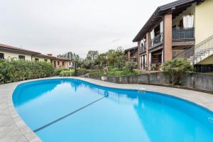 a large blue swimming pool in front of a house at Residence La Piopa in Polpenazze del Garda