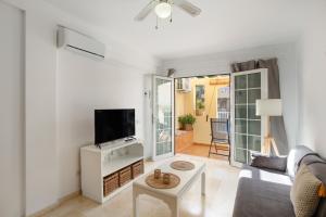 a living room with a couch and a tv at Mangueros Suite 4 Puerto de Mogán in Puerto de Mogán
