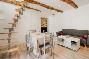 een woonkamer met een tafel en een bank bij Dépendance au charme local in Saint-Carné