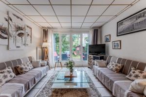 a living room with a couch and a table at La Palmeraie 300m plage, calme in Arcachon