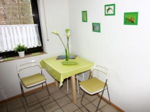 d'une table et de deux chaises avec un vase. dans l'établissement Seepark Falk Wohnung Nr -2-, à Fribourg-en-Brisgau