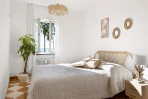 a white bedroom with a bed and a potted plant at Villino Rosanna in Bogliasco +24 photos