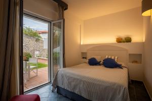 a bedroom with a bed with blue pillows on it at Le Ruve Bianche in Vibonati +123 photos