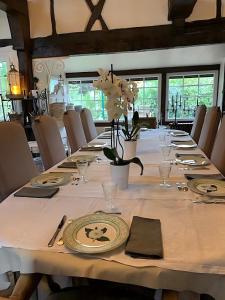 einen langen Tisch mit Tellern und Servietten darauf in der Unterkunft Chic et Charme Cottage in Suzay