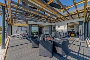 a patio with chairs and tables on a wooden deck at Villa vue Mer - Les Gîtes de Fabie in Plougonvelin