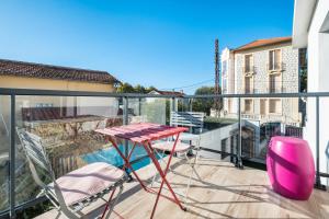 a balcony with a red table and chairs on it at T3 Cros De Cagnes Bord De plage in Cagnes-sur-Mer