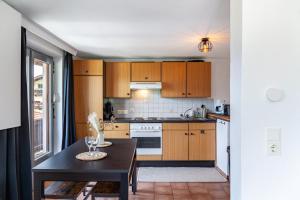 a kitchen with wooden cabinets and a black table at Feichtenhäusl app 1 in Westendorf +18 photos