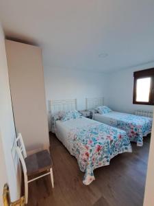 ベレス・ルビオにあるCasa Pedroのベッド2台と椅子と窓のある寝室